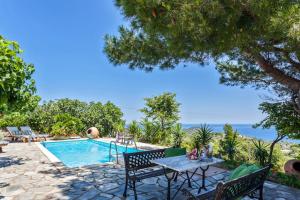 Villa con piscina, mesa y sillas en Villa Driades, en Skopelos Town