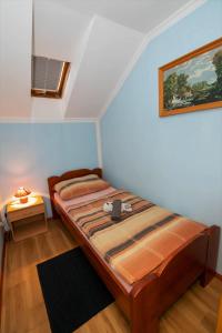 a small bedroom with a bed and a table at Apartments Orel in Mozirje