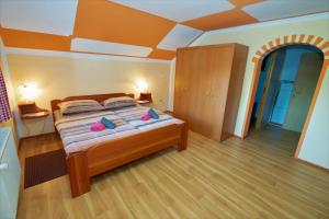 a bedroom with a bed with two pink pillows on it at Apartments Orel in Mozirje