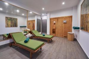 a waiting room with green chairs and wooden cabinets at Hotel Quinta Do Furao in Santana