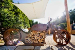 a statue of a bike with a cart full of logs at Red Rock Resort in Kurort Oybin