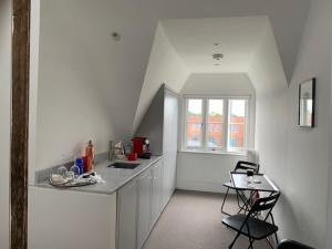 a white kitchen with a counter and a window at Montys Accommodation in Lewes
