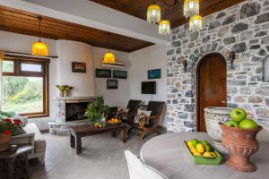 a living room with a table and a stone wall at Villa Driades in Skopelos Town