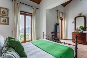 a bedroom with a bed with a mirror and a window at Villa Driades in Skopelos Town +36 photos