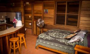 サン・アグスティンジョにあるLas Cabañas Mágicasのベッドルーム1室(ベッド1台付)、キッチン(ファン付)