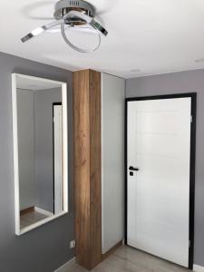 a room with a white door and a mirror at Apartament Łeba Kosciuszki Centrum in Łeba