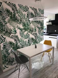 a kitchen with a table and two chairs and a wall at Apartament Łeba Kosciuszki Centrum in Łeba