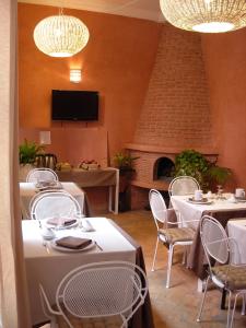 a restaurant with tables and chairs and a fireplace at Riad Aderbaz in Marrakech