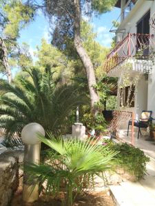a garden in front of a house with palm trees at Apartment Kordić in Sveta Nedelja