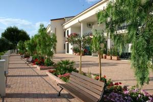 a row of benches in front of a building with flowers at Residence Chiesiola in Vieste