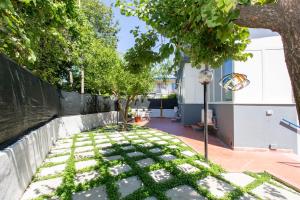 a garden with a sidewalk with grass and a street light at Casa vacanze Le tre rose in Sant'Agnello