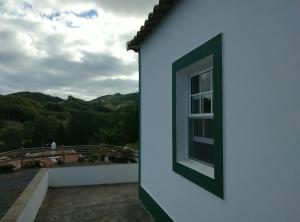 a window on the side of a house with a view at Casa dos Valentes in Santo Espírito