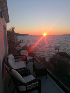 d'un balcon avec des chaises et une vue sur le coucher du soleil. dans l'établissement Vila Apartments Marina, à Blato