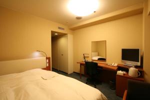 Un pat sau paturi într-o cameră la Smile Hotel Sendai-Kokubuncho