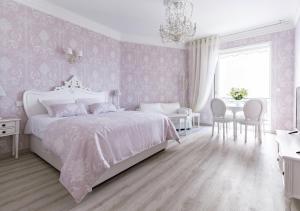 una camera con letto bianco e tavolo e sedie di Palais Miramar Imperial Croisette a Cannes