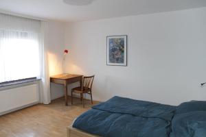 ein Schlafzimmer mit einem Bett, einem Tisch und einem Schreibtisch in der Unterkunft Bike and Hike Ferienhaus Kolverath in Kolverath