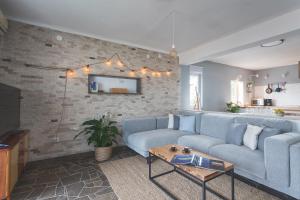 uma sala de estar com um sofá azul e uma parede de tijolos em The Island Place em Bol