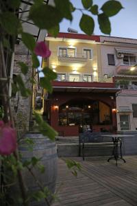 a building with a balcony and a building with pink flowers at Under the Aqueduct boutique house in Kavála