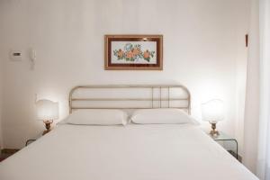 ソレントにあるイル パラツェットのベッドルーム1室(白いベッド1台、ランプ2つ付)