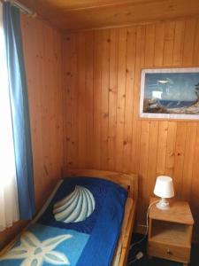 a bedroom with a bed in a wooden cabin at Domek Muszelka in Karwia