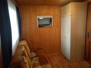 a room with wooden walls and a window and a cabinet at Domek Muszelka in Karwia