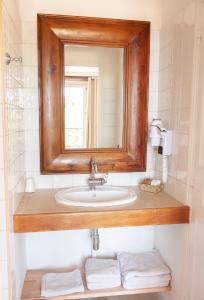 a bathroom with a sink with a mirror and towels at Auberge du Vieux Château in Cabris