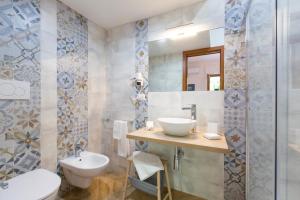 聖安吉洛的住宿－Casa vacanze Le tre rose，一间带水槽、卫生间和镜子的浴室