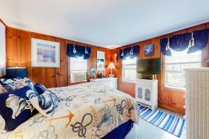 una camera con letto e pareti e finestre in legno di Paradise by Ocean Edge a Brewster