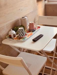 una mesa con una bandeja de comida y un mando a distancia en Casa do Canto en Vila Nova de Milfontes