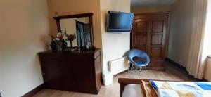 a bedroom with a dresser and a mirror and a blue chair at Creevagh (Room Only) in Keel
