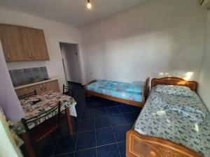 a small room with two beds and a table at Hillside Apartments in Borsh