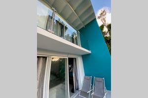 two chairs sitting on a balcony next to a building at L'ylang ylang in Petit-Bourg
