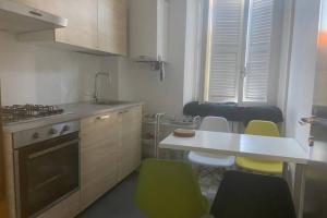 a kitchen with yellow chairs and a white counter top at Appartamento nel centro storico in Ancona
