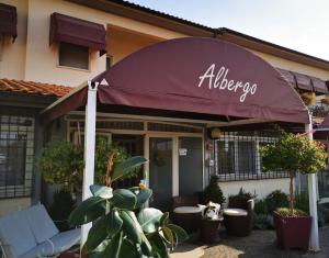 um restaurante com um guarda-chuva em frente a um edifício em Hotel La Rosa Dei Venti em Albinia