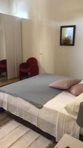 Cama grande en habitación con sillas rojas en Monolocale arredato con una camera, en Parma
