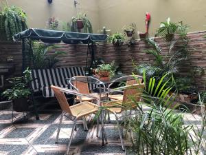 een patio met een tafel, stoelen en planten bij B&B Cusing Wasi in Lima