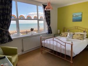 a bedroom with a bed and a view of the beach at Mariners Hotel in Seaton