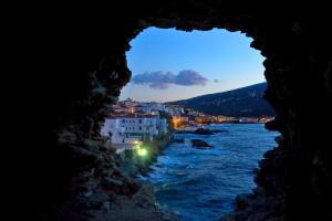 a view of a river from a cave at night at By the sea in Andros +19 photos