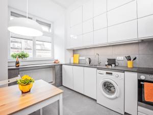 a kitchen with a washing machine and a table at Best INN Poznań Apartament Orzeszkowej in Poznań