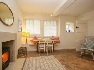 a living room with a fireplace and a table and chairs at 10 George Yard in Burford