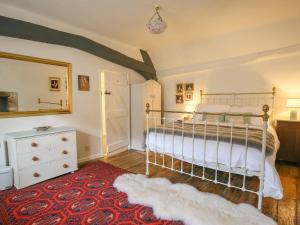 a bedroom with a bed and a red rug at 10 George Yard in Burford