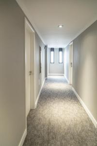 an empty hallway with white walls and carpeted floors at Hotel Bella Paulista in São Paulo