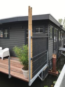 una pequeña casa negra sentada en una terraza de madera en nummer 100 - 2, en Leeuwarden