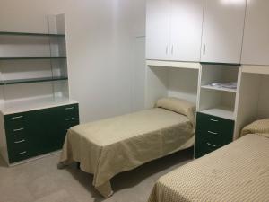 Habitación con 2 camas, armarios blancos y estanterías en Casa Giò, en Cisternino