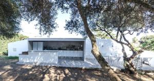 una casa blanca con una mesa y un árbol en Starbal Love, en Es Castell