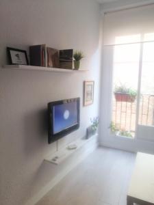 sala de estar con TV de pantalla plana en la pared en Apartamento en el Rastro, en Madrid