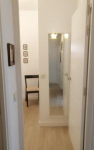 przedpokój z lustrem i krzesłem w pokoju w obiekcie Apartamento en el Rastro w Madrycie