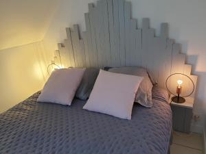 um quarto com uma cama grande e 2 almofadas brancas em Duplex de Léane em Honfleur