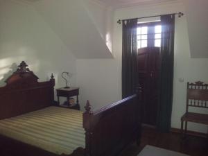 a bedroom with a canopy bed and a window at Casa Cardoso in São Martinho de Mouros
