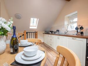 a kitchen with a table with a bottle of wine at Hendre Cottage in Trawsfynydd